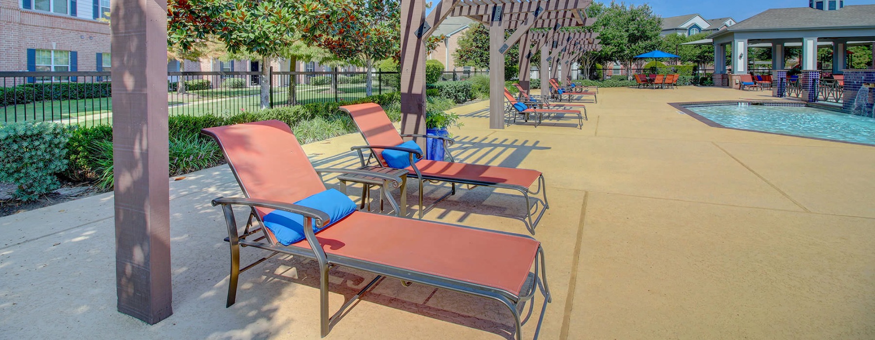 pergola shaded lounge chairs near pool